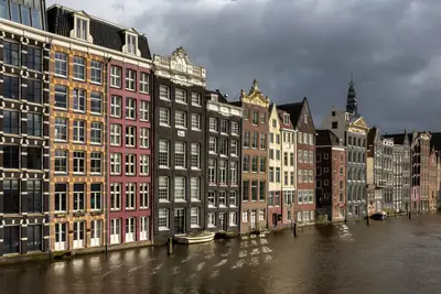 Colourful gabled houses along the Damrak at golden hour