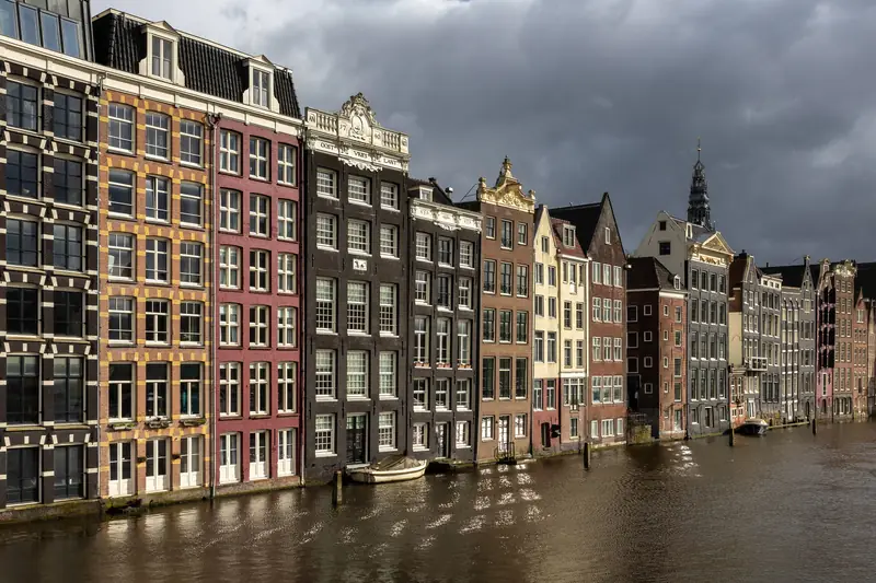 Colourful gabled houses along the Damrak at golden hour
