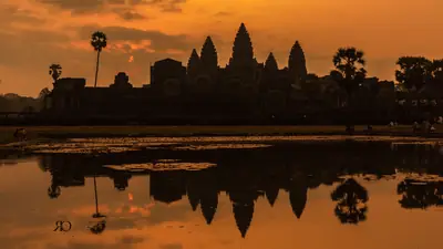 Angkor Wat's towers reflected in a pool at sunrise