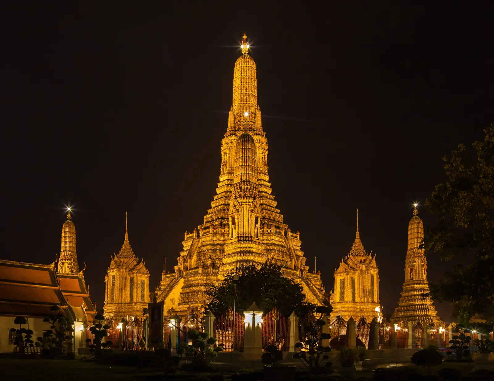 Wat Arun on the Chao Phraya River, Bangkok, lit up at dusk