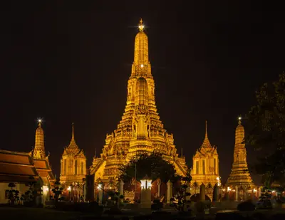 Wat Arun on the Chao Phraya River, Bangkok, lit up at dusk