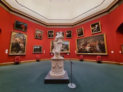 Paintings hung on red walls in the Scottish National Gallery