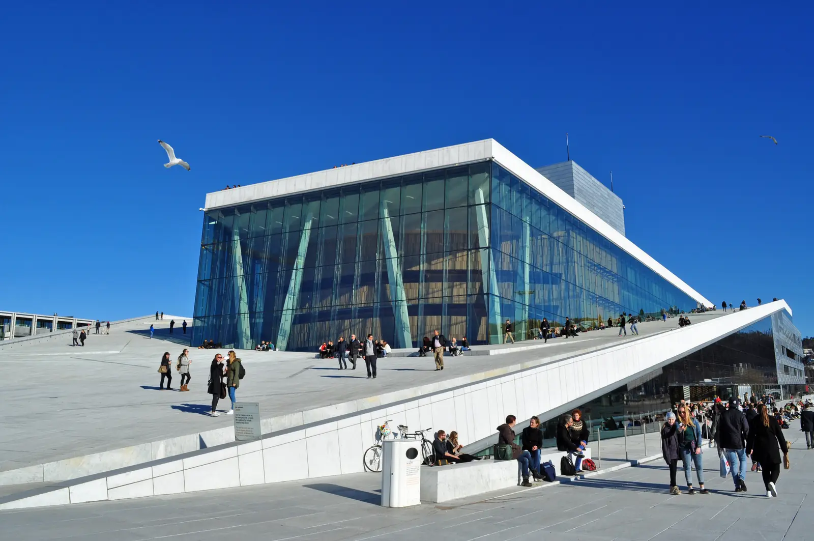 Visitors walking on the sloping roof of the Oslo Opera House