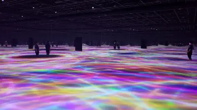 Visitors wading through a light-filled installation at teamLab Planets TOKYO